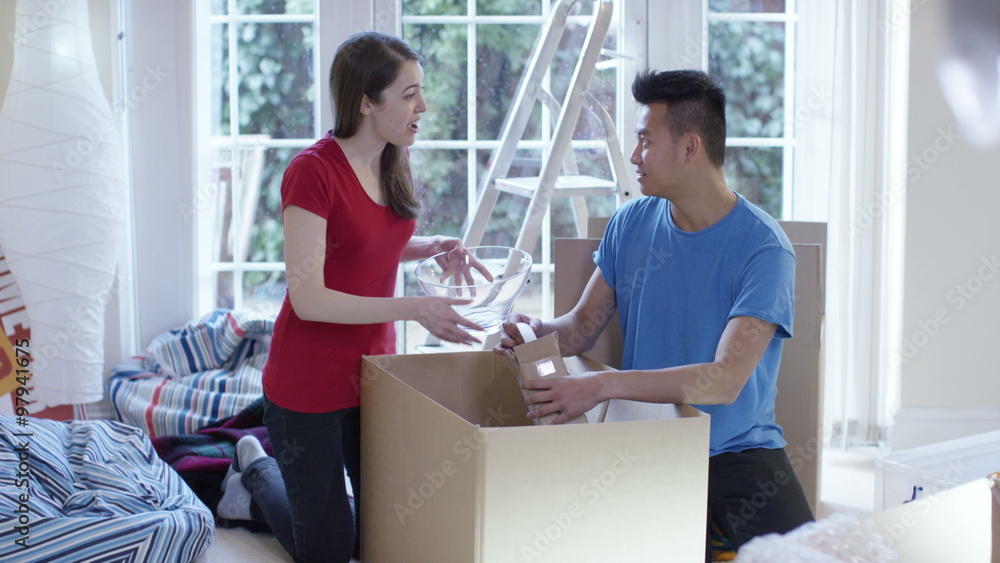 Happy young couple unpacking boxes, moving into new home Happy young couple unpacking boxes, moving into new home