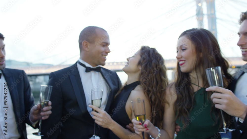 Romantic couple in love share a kiss at celebration party with friends Romantic couple in love share a kiss at celebration party with friends