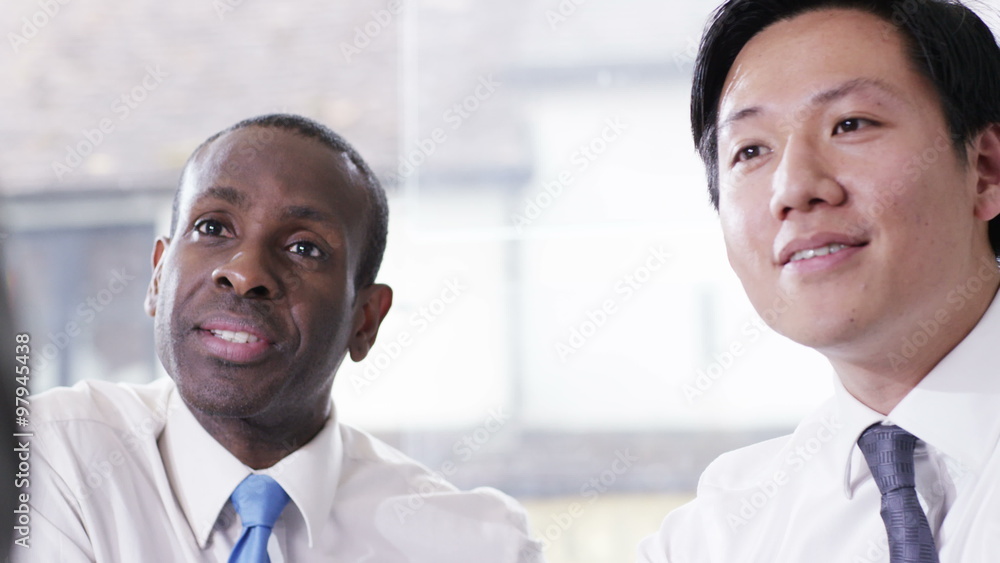 Two businessmen interviewing a candidate for new job or negotiating de Two businessmen interviewing a candidate for new job or negotiating de