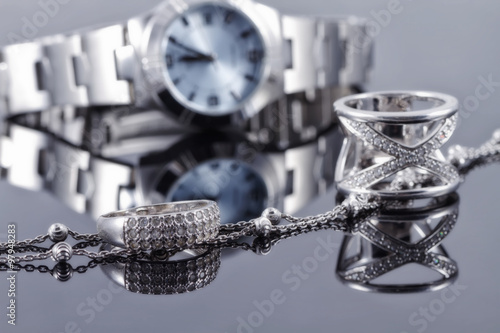 Silver rings and silver chain on the background of women's watch