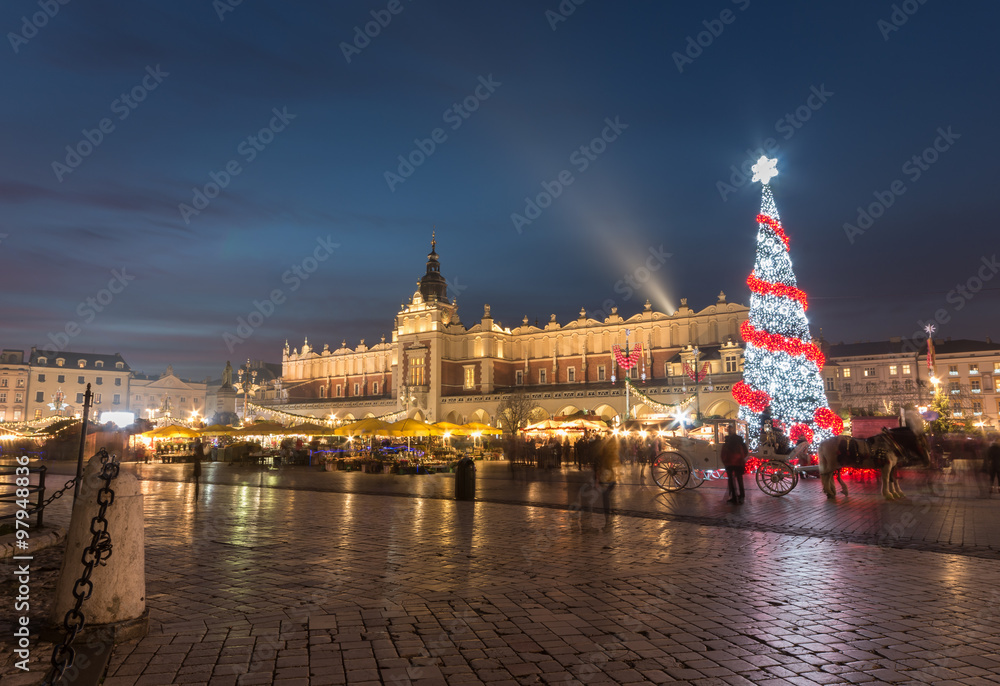 Krakow, Poland, Main Market square and Cloth Hall in the winter season, during Christmas fairs decorated with Christmas tree.