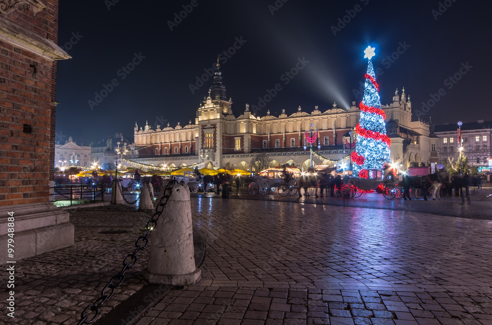 Obraz premium Krakow, Poland, Main Market square and Cloth Hall in the winter season, during Christmas fairs decorated with Christmas tree.
