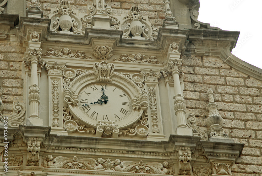 MONTSERRAT, SPAIN - AUGUST 28, 2012: Benedictine abbey Santa Maria de Montserrat in Monistrol de Montserrat, Spain. Details of the church clock