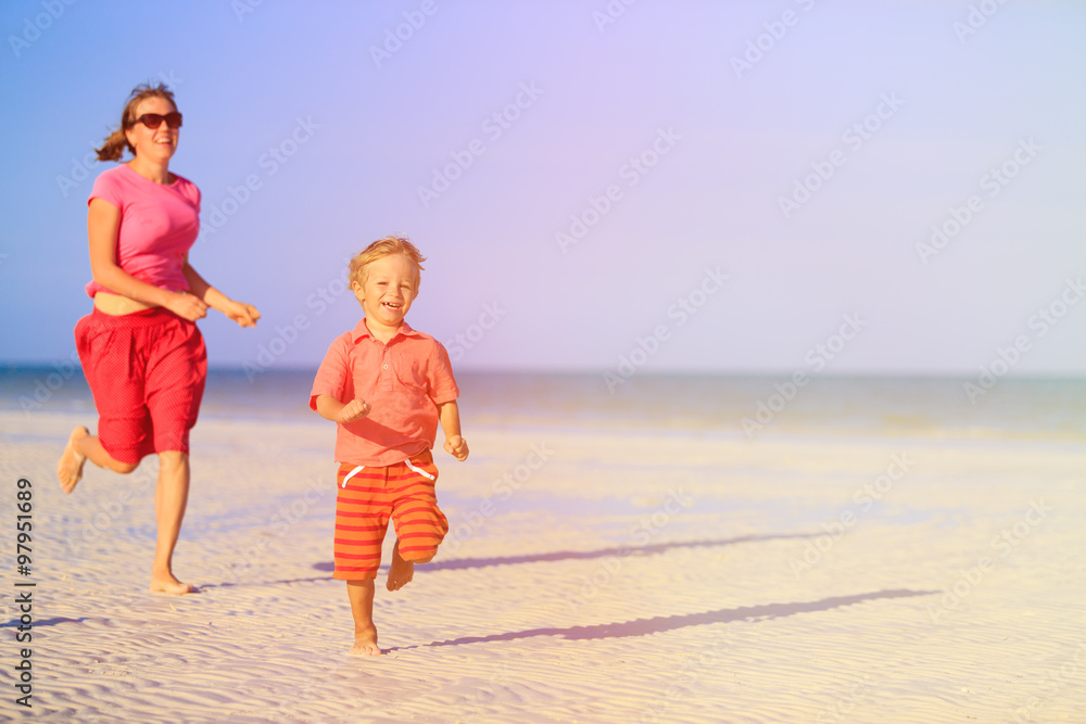 happy little boy with mother running on beach