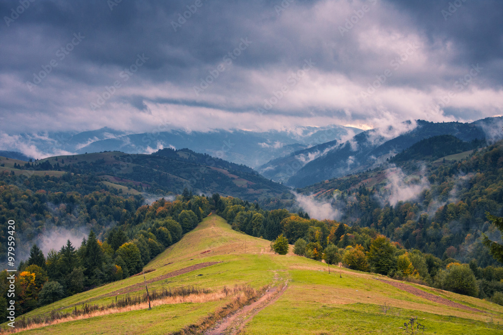 Cloudy autumn day in mountains . Green hills . Fairy landscape .