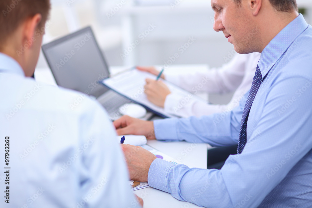 Business people sitting and writting at business meeting, in office Business people sitting and writting at business meeting, in office