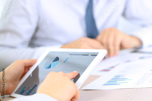 Business colleagues working and analyzing financial graphs on a