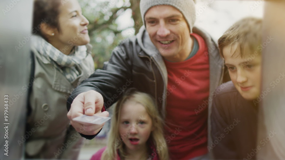 Cheerful family group withdrawing money from an ATM machine Cheerful family group withdrawing money from an ATM machine