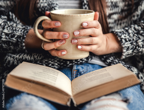 girl having a break with cup of fresh coffee after reading books or studying