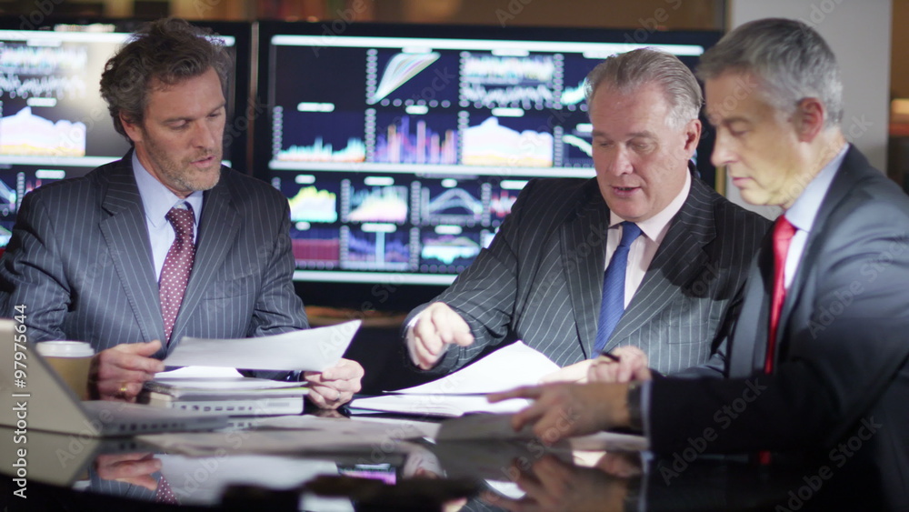 Mature male businessmen in a meeting analysing figures and statistics Mature male businessmen in a meeting analysing figures and statistics