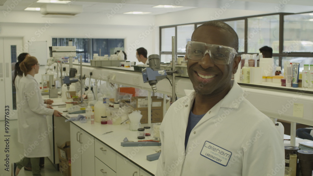 Black male scientist poses for camera. Science Lab and scientists working on cosmetics, medicines and food analysis. Pharmaceutical industry Black male scientist poses for camera. Science Lab and scientists working on cosmetics, medicines and food analysis. Pharmaceutical industry