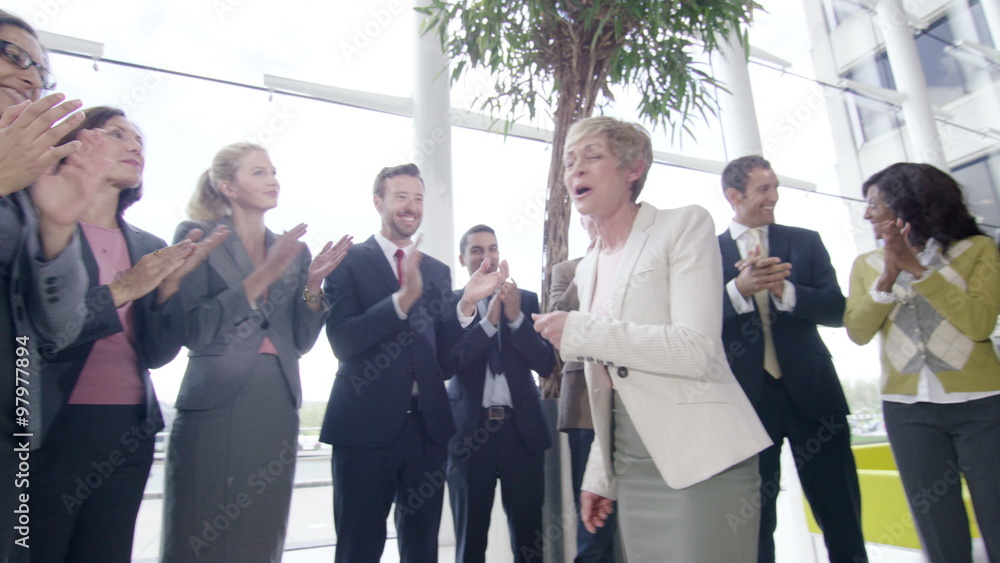 Confident diverse business team applauding their success and shaking hands Confident diverse business team applauding their success and shaking hands