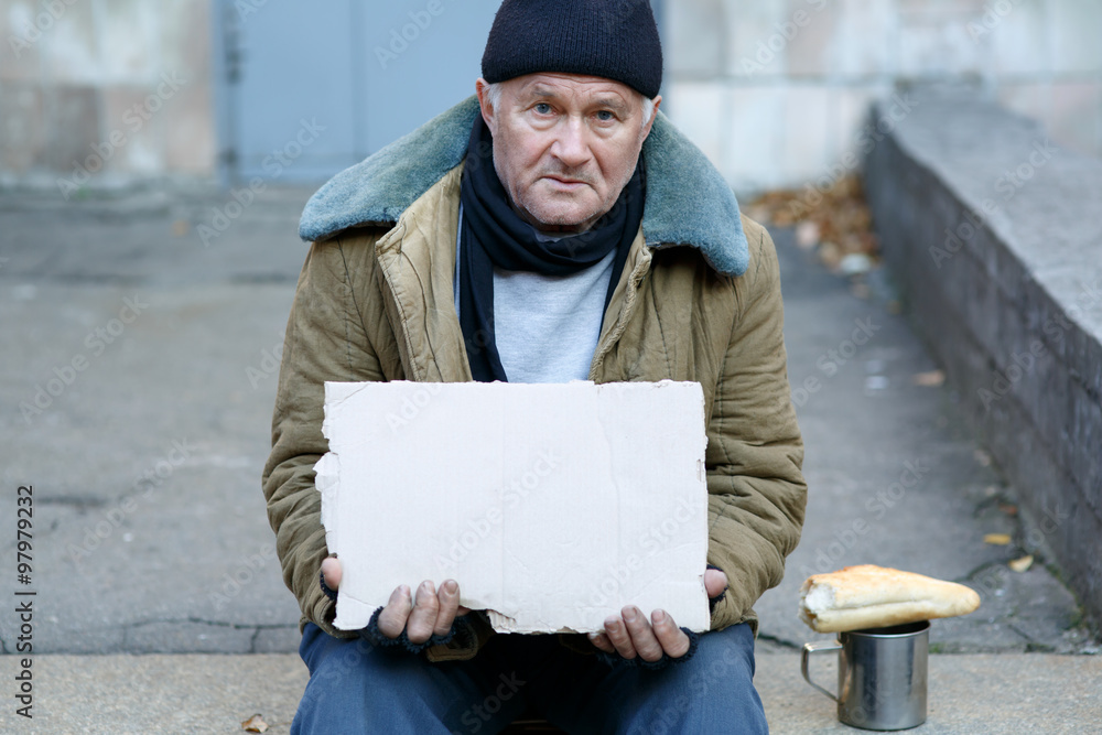 Homeless man holding a cardboard sign. Homeless man holding a cardboard sign.