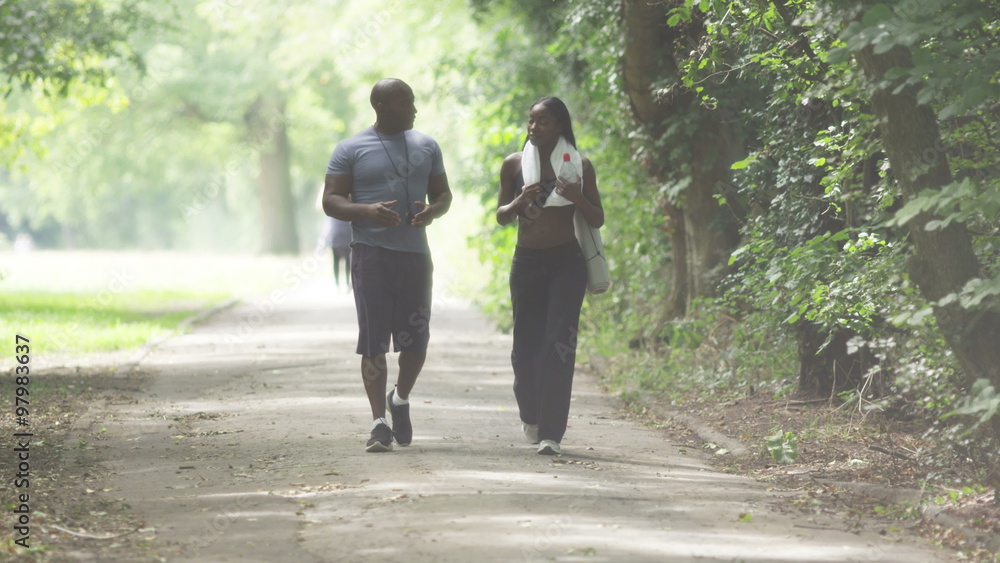 Young sports woman with personal trainer walking and talking in slow motion Young sports woman with personal trainer walking and talking in slow motion