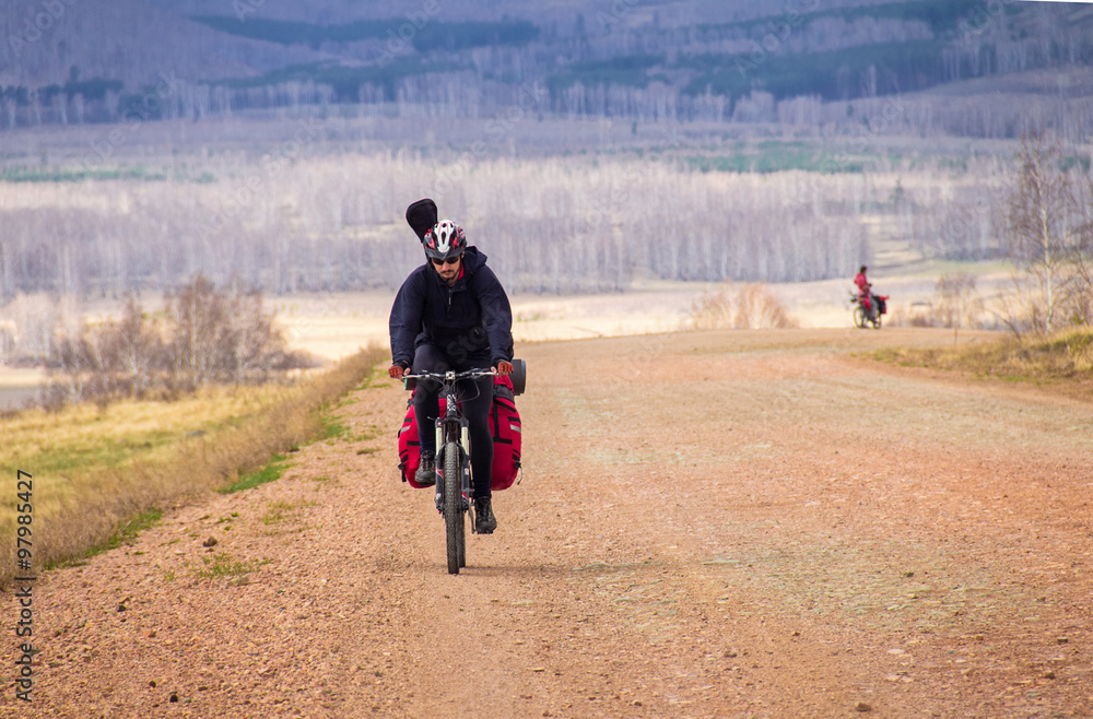 Cycling tourist rides on dirt road