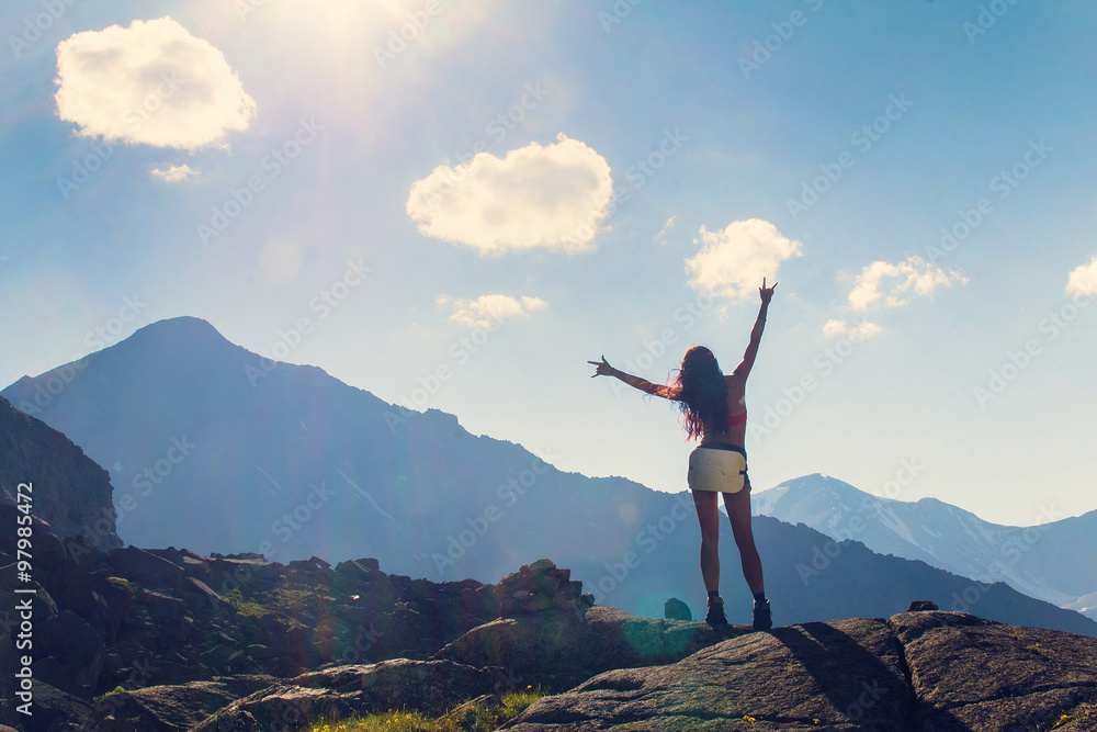 Woman raised her hands up in the mountains