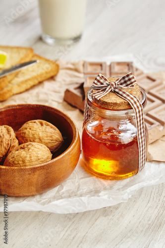 Closeup beautiful jar with honey with wooden cap laced as gift