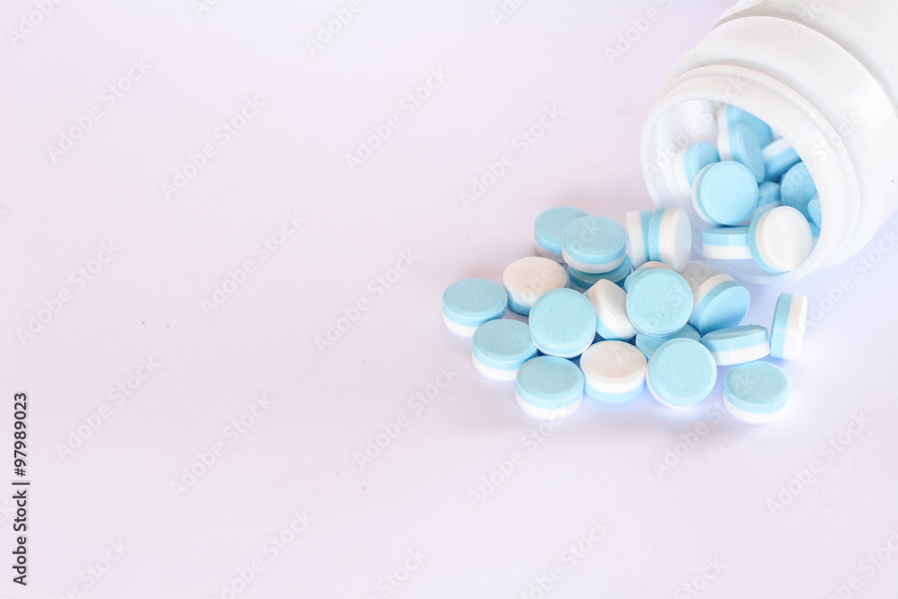 Blue and white pills out of the bottle. Blue and white pills out of the bottle.