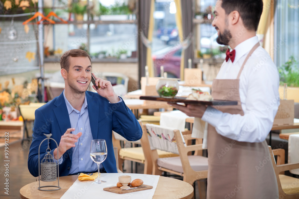 Attractive male cafe worker is serving the customer Attractive male cafe worker is serving the customer