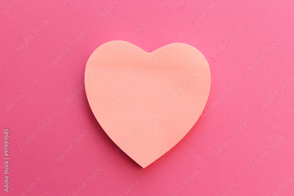 Blank pink paper note heart shape on pink background with copy space