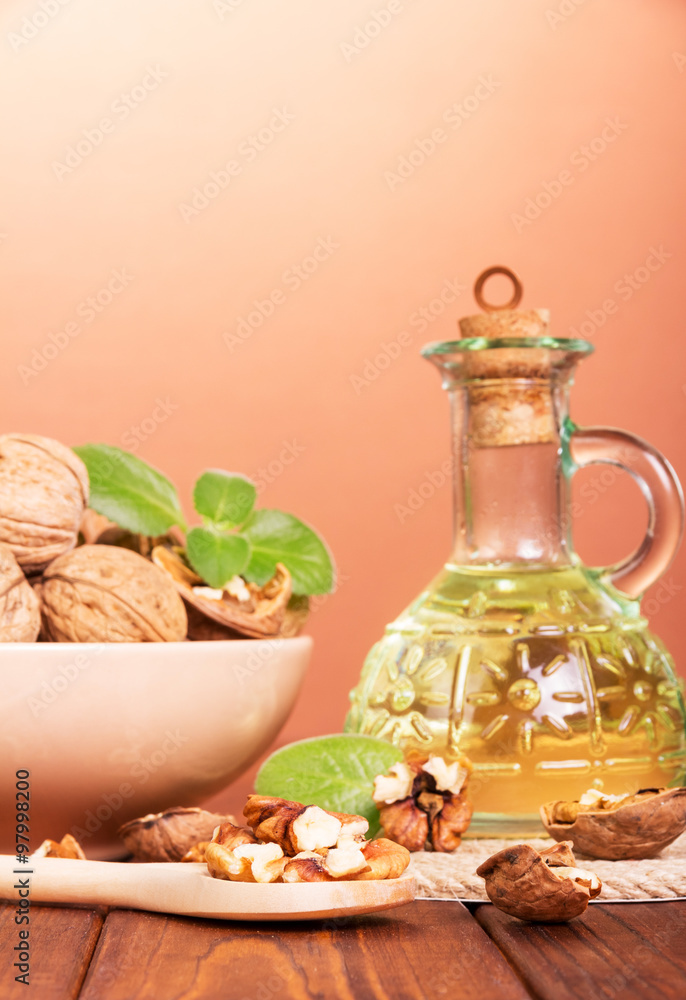 Bottle with oil and whole walnuts close-up Bottle with oil and whole walnuts close-up