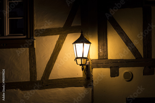 Traditional ancient street lamp on stone wall at night
