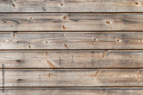 Weathered larch wooden planks on the building facade with blue stain and mold