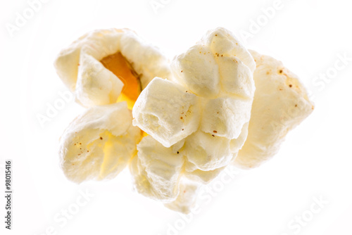 Macro photograph of a piece of popcorn o a blown out white background.
