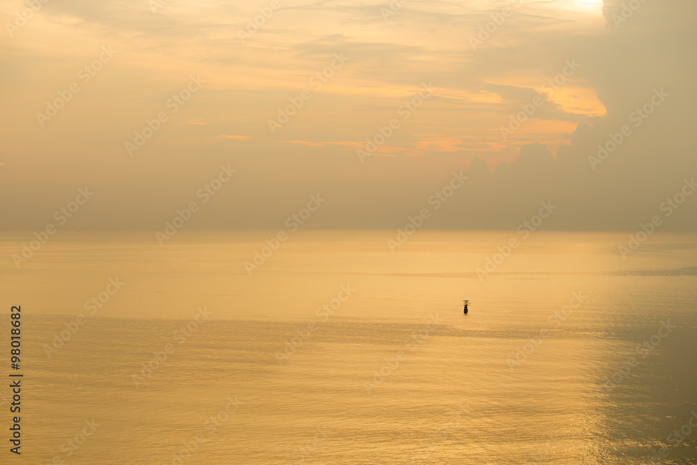 sunset of flashing buoy floating on calm sea