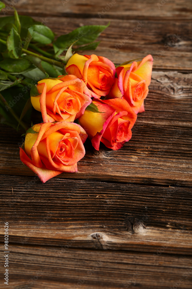 Bouquet of orange roses on brown wooden background Bouquet of orange roses on brown wooden background
