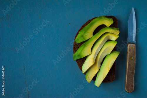 Sandwich with avocado slices on rye bread and knife