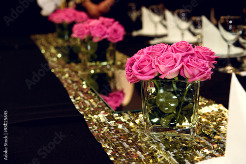 stylish luxury decorated tables with roses at the golden birthda photo