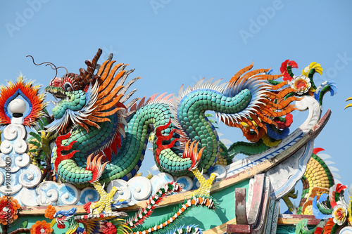 colorful dragon statue against blue sky.