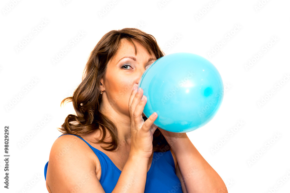 Beautiful middle-aged woman inflates a balloon. Beautiful middle-aged woman inflates a balloon.