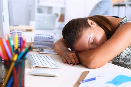 Office life. Young woman sleeping at workplace