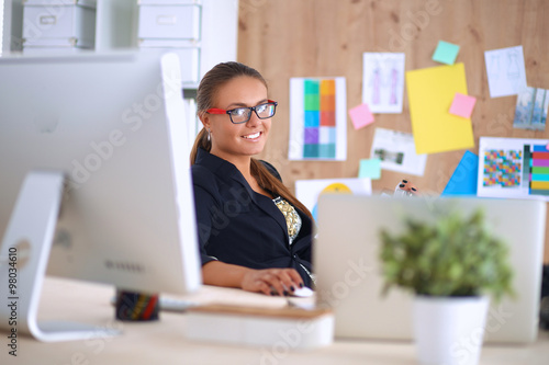 Fashion designers working in studio sitting on the desk