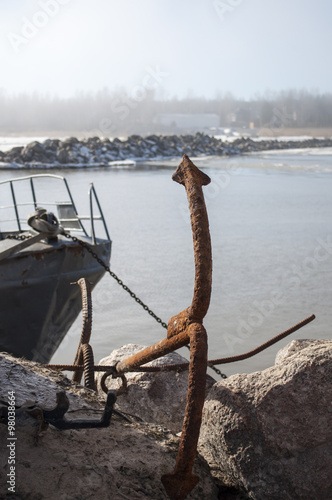 Old rusty anchor. The nose fishing schooner. Coast fog.