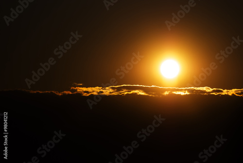 Orange solar disk and clouds closeup