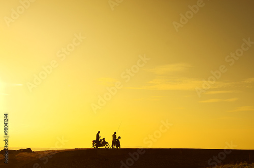 silhoutte of a man standing with his bike during beautiful golde