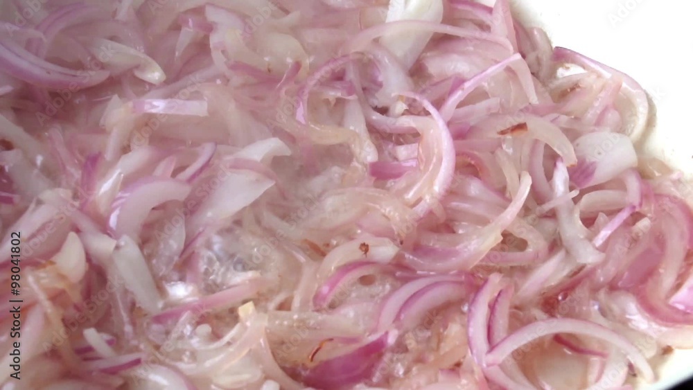 Frying sliced red onions in ceramic wok pot-close up Frying sliced red onions in ceramic wok pot-close up