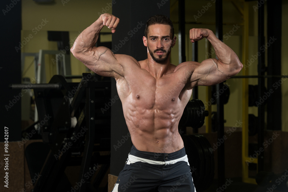 Bodybuilder Performing Rear Double Biceps Pose Bodybuilder Performing Rear Double Biceps Pose