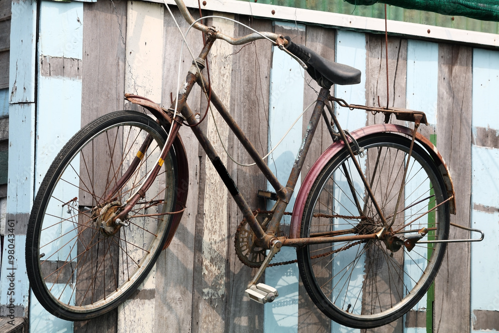 classic bicycle hanging on wooden wall.