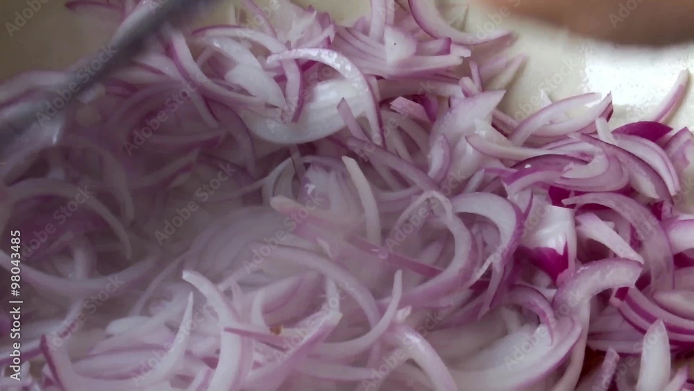 Frying sliced red onions in ceramic wok pot-close up Frying sliced red onions in ceramic wok pot-close up