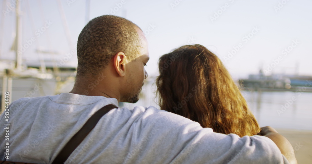 Romantic couple in summer, kissing & looking out at the boats in the harbor. Romantic couple in summer, kissing & looking out at the boats in the harbor.