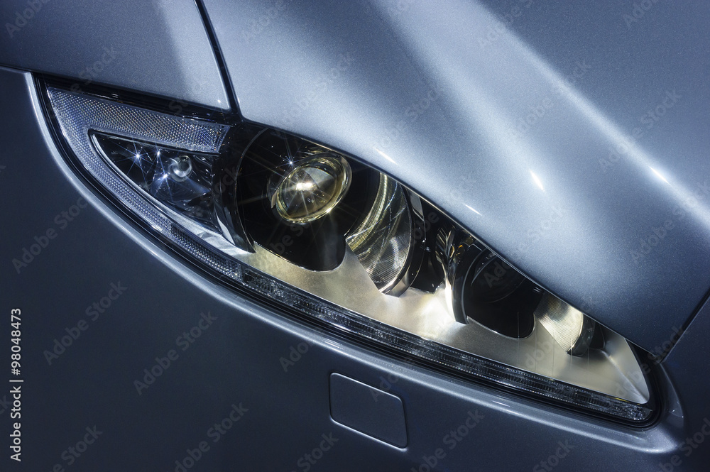 Headlight and hood of powerful sports car with stars on lamps, sedan bodywork with silver blue glossy coating, luxury transportation industry 