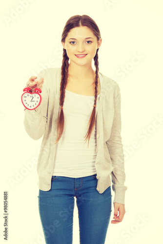 Happy teenage woman with alarmclock. © Piotr Marcinski