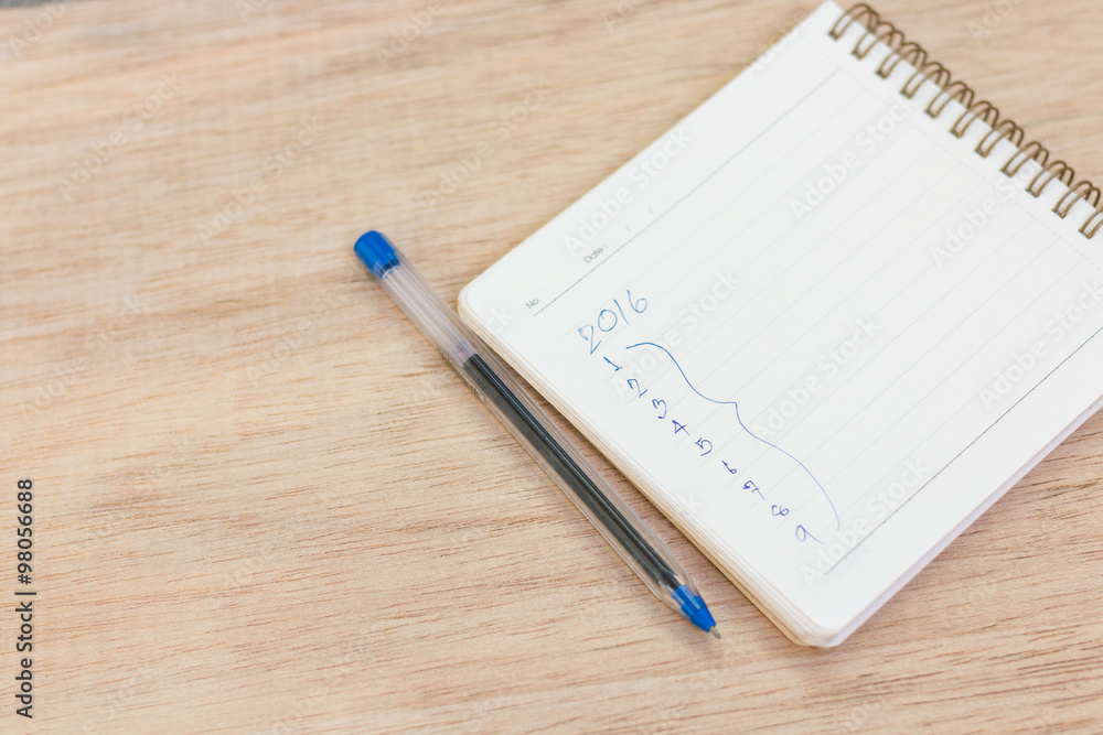 Goals for 2016 - checklist on notepad with pen on wooden backgro Goals for 2016 - checklist on notepad with pen on wooden backgro