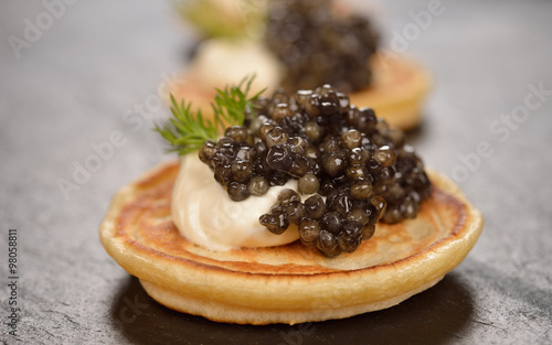 Mini pancakes with black caviar