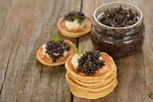 Mini pancakes with black caviar