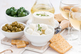 fresh soft cheeses, crackers and pickles to wine on table